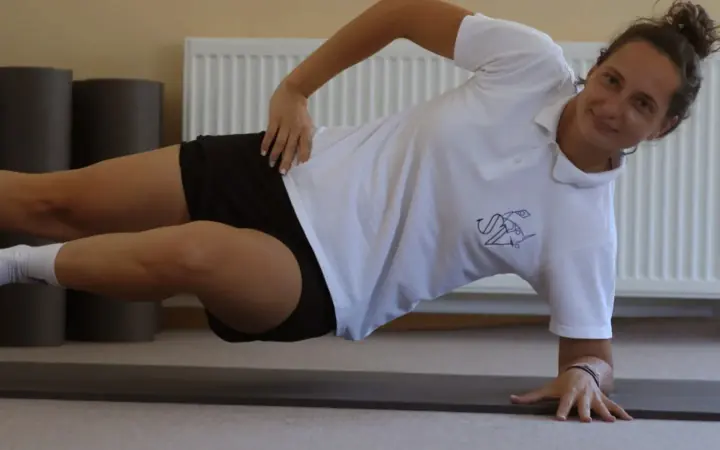 Sanja se smeje dok radi bočni plank na podlozi